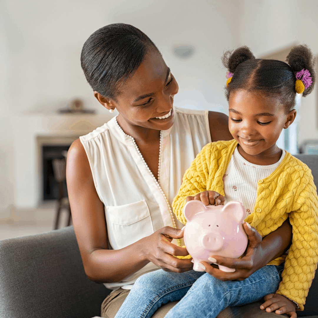 Parent holding child with piggy bank