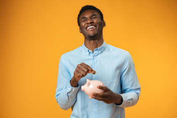 Teen smiling with Piggy bank